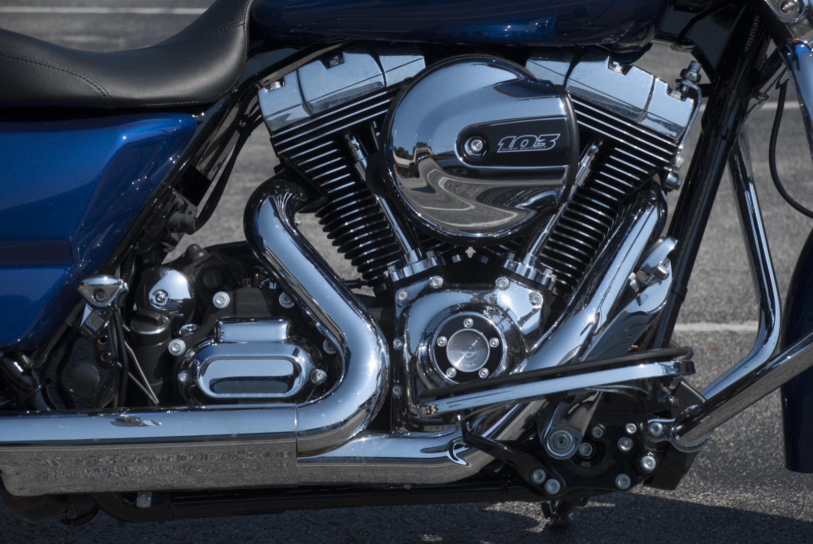 A blue Harley-Davidson with the chrome 103 V-twin engine in the sunlight.