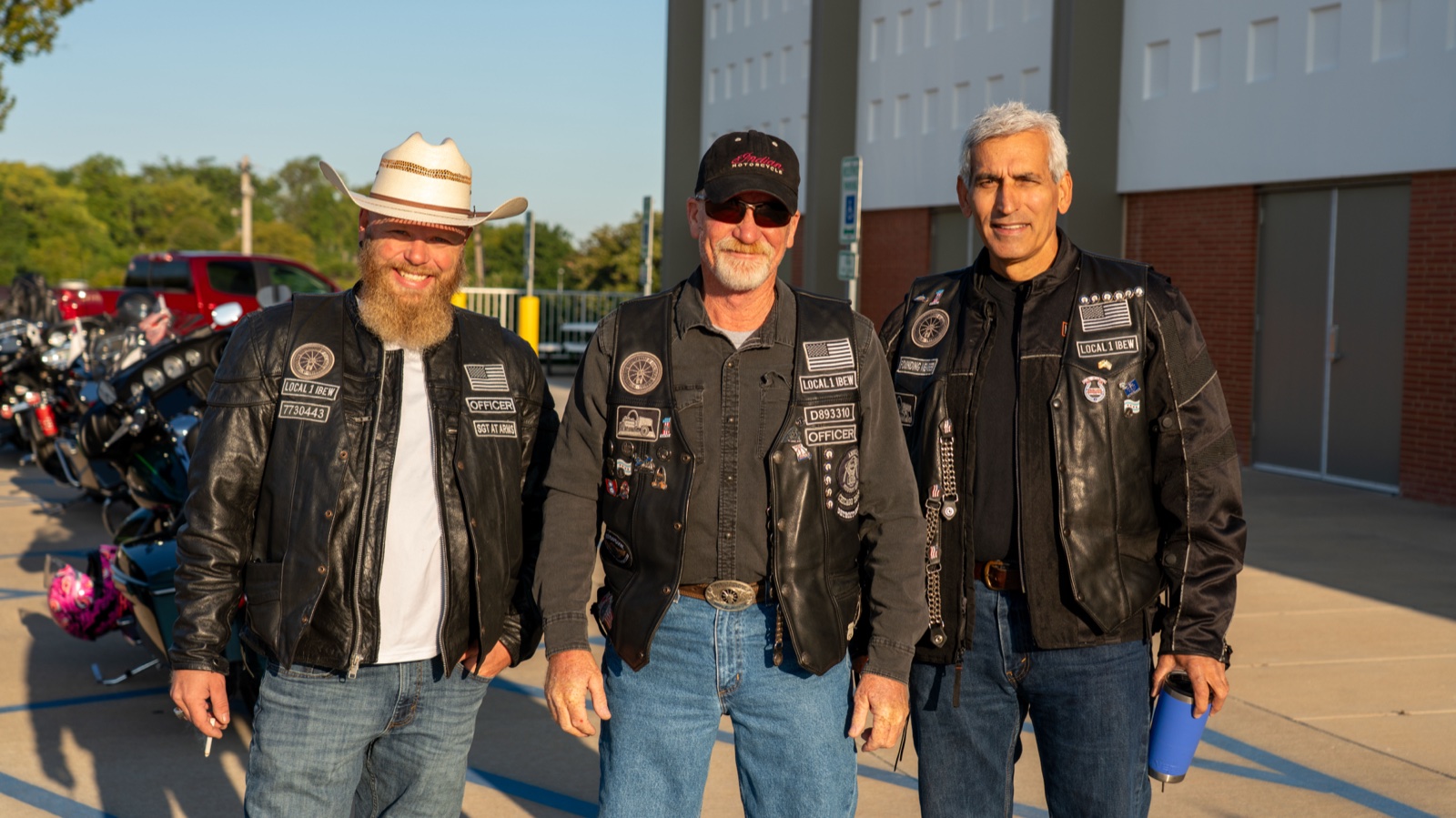Three EWRC1 members in their club vests with charter member and officer patches visible, standing together at the Local 1 hall.
