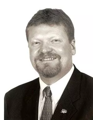 Portrait of Greg Booth, IBEW Local 1 Business Manager, in coat and tie. Photo from the electricalconnection.org obituary.